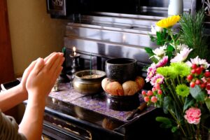 仏壇に手を合わせる人